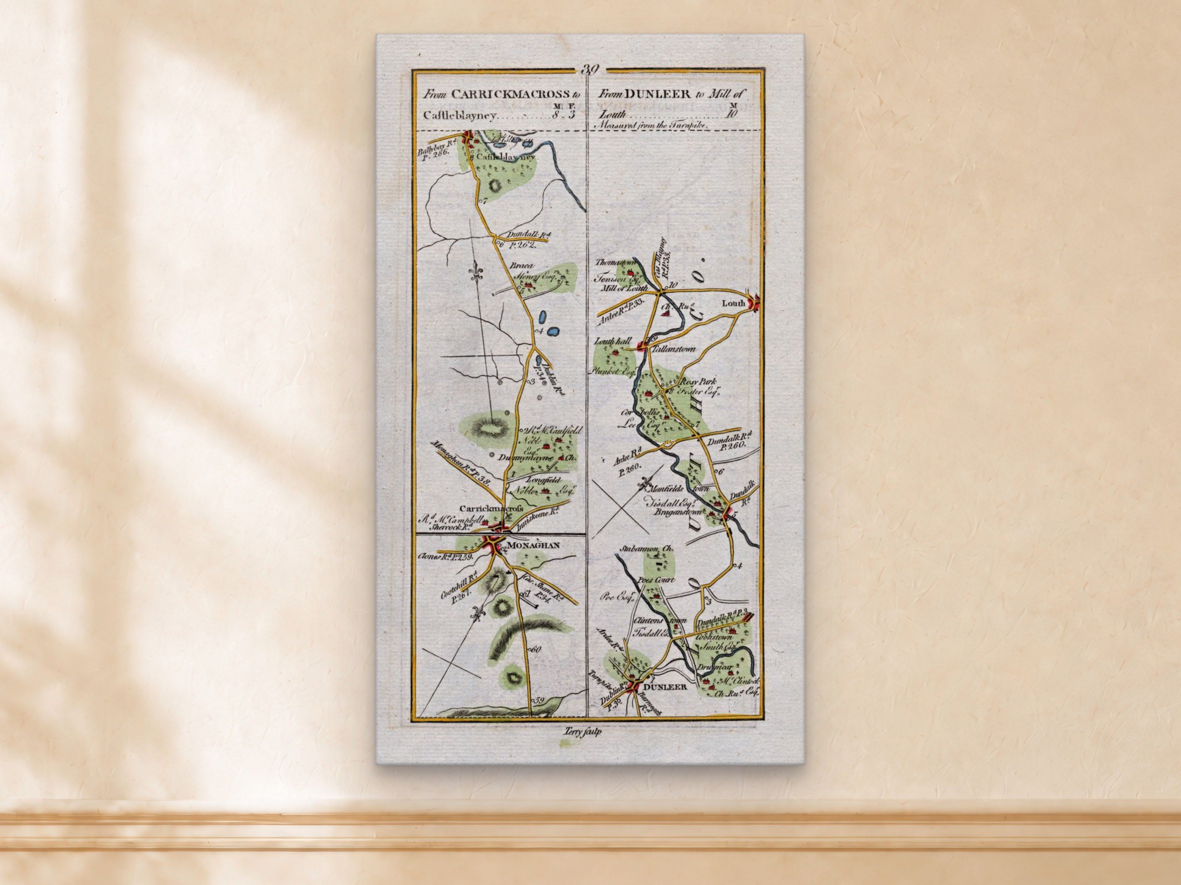 1783 Taylor & Skinner Carrickmacross, Castleblayney, Dunleer, Louth and Monaghan Ireland road map displayed on a light cream wall. The map covers Counties Louth and Monaghan.