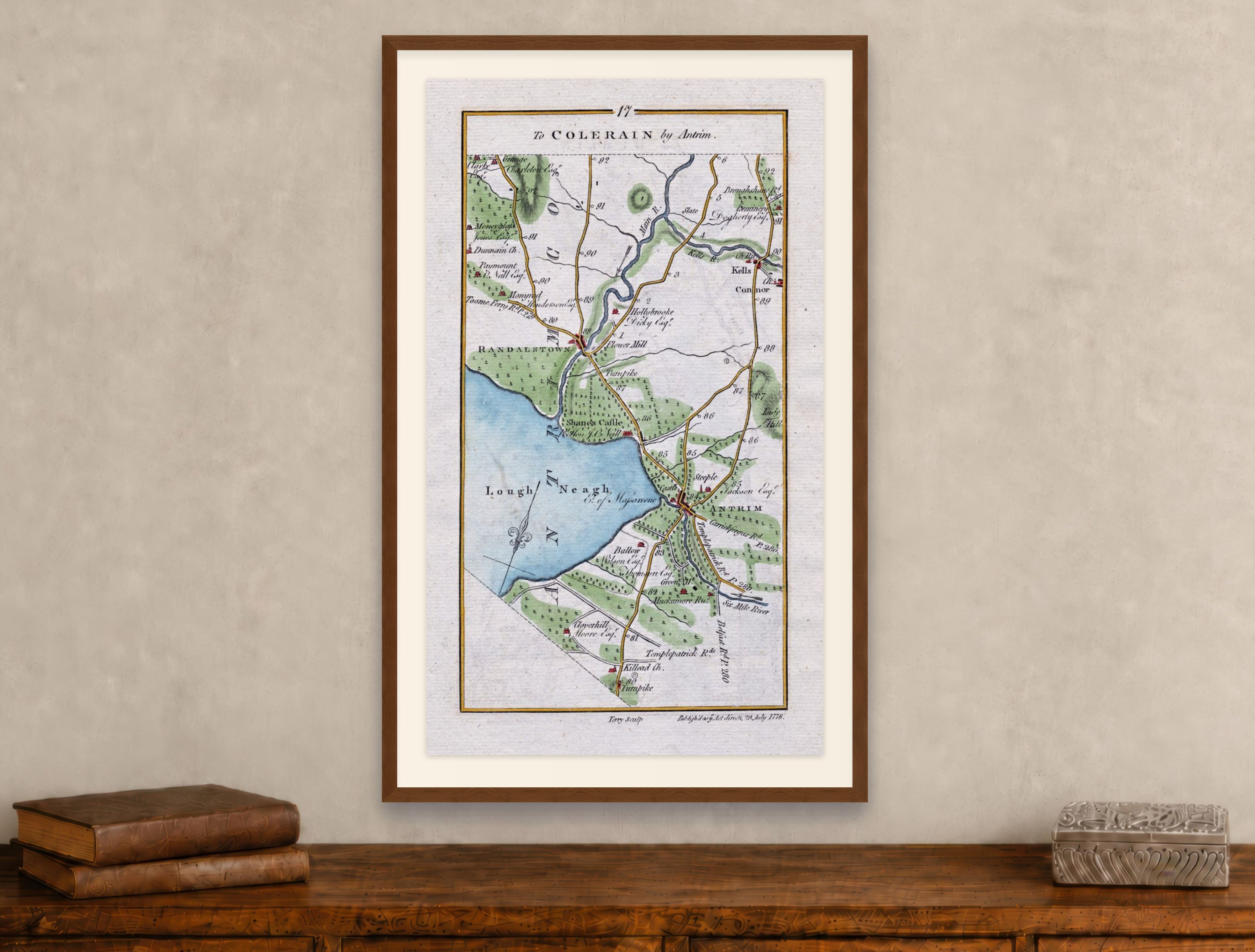Framed 1783 Taylor & Skinner Antrim, Randalstown, Kells, Connor and Grange, Ireland road map displayed above an antique wooden cabinet.
