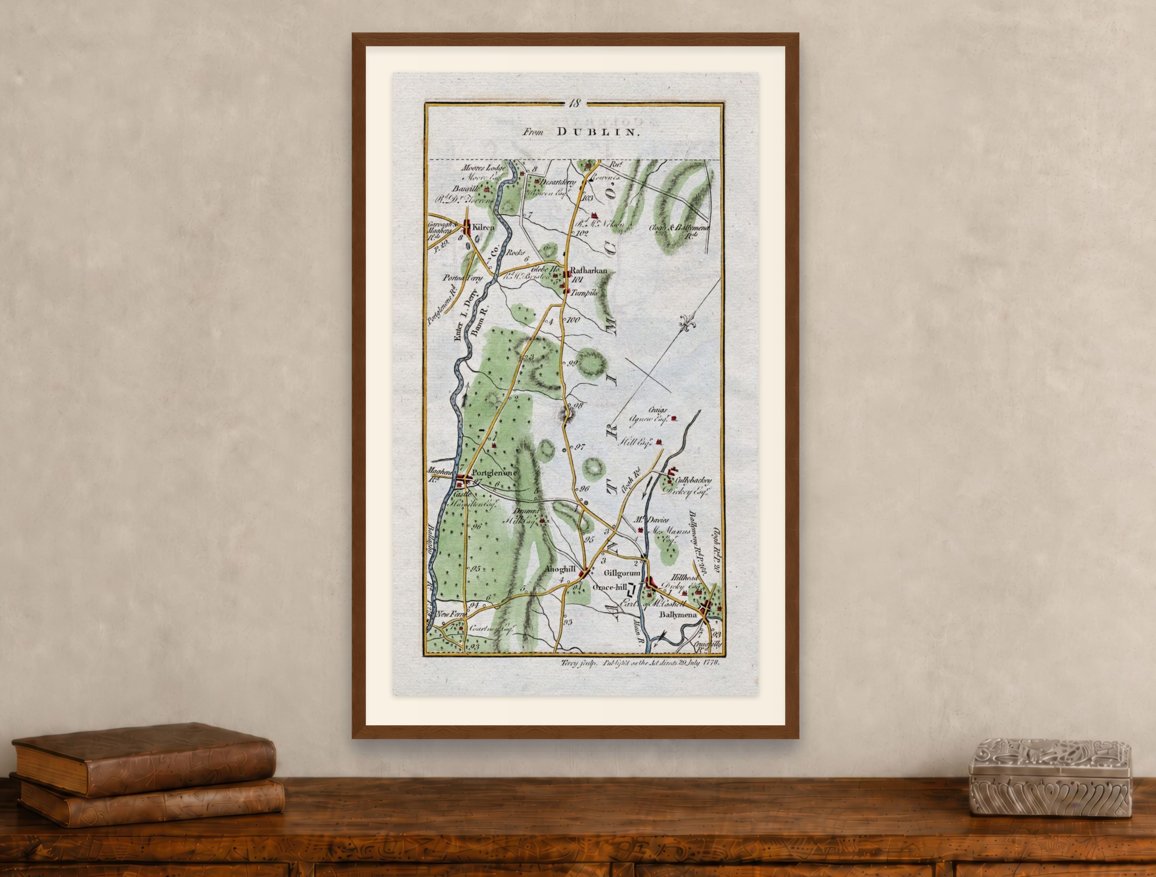 Framed 1783 Taylor & Skinner Ballymena, Portglenone, Kilrea and Cullybackey, Ireland road map displayed above an antique wooden cabinet.