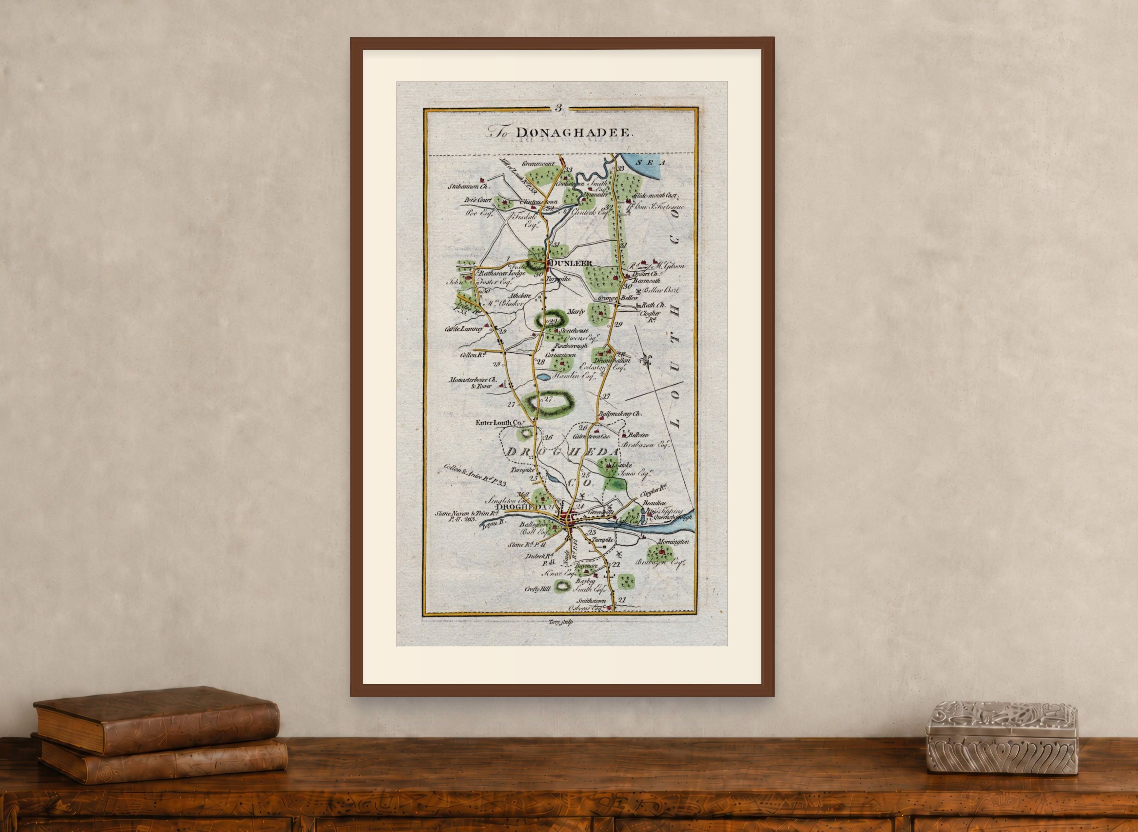 Framed 1783 Taylor & Skinner Drogheda, Dunleer, Monasterboice and Stabannon road map displayed above an antique wooden cabinet