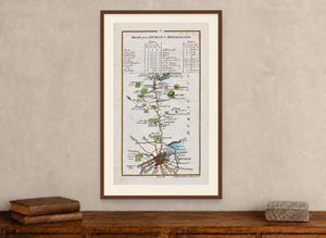 Framed 1783 Taylor & Skinner Dublin to Donaghadee road map displayed above an antique wooden cabinet.