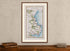 Framed 1783 Taylor & Skinner Lusk, Rush, Skerries and Balbriggan road map displayed above an antique wooden cabinet.