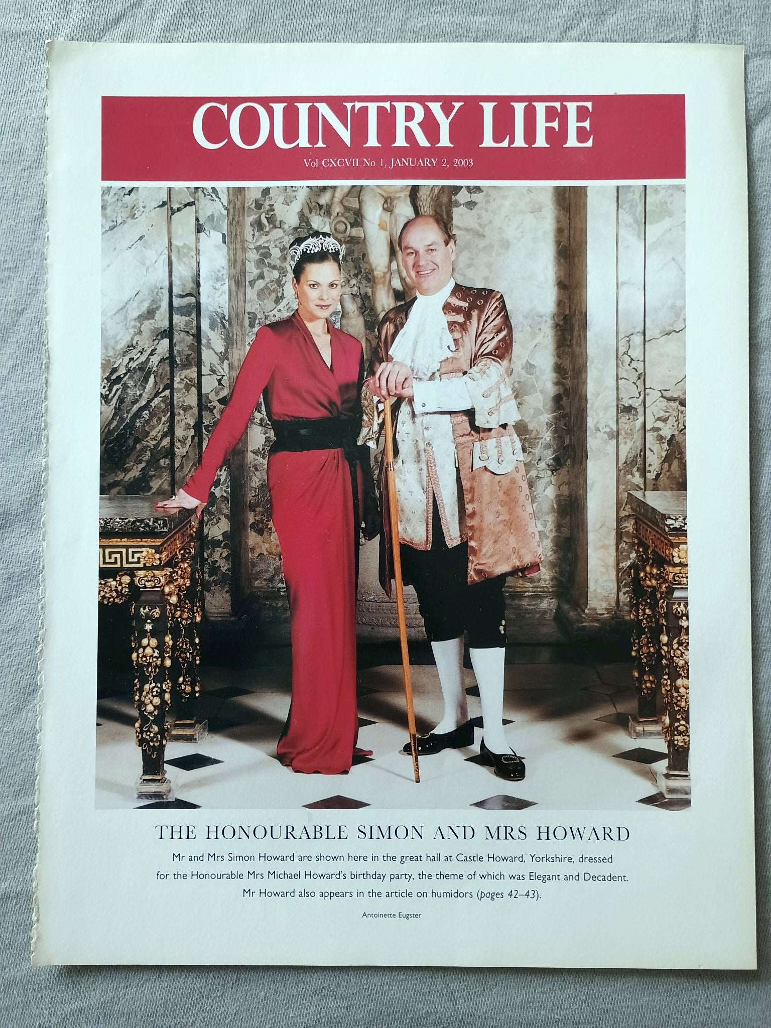 The Honourable Simon and Mrs Howard - Mr and Mrs Simon Howard are shown here in the great hall at Castle Howard, Yorkshire, dressed for the Honourable Mrs Michael Howard's birthday party, the theme of which was Elegant and Decadent. Mr Howard also appears in the article on humidors