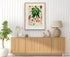 1879 Anthurium gladiifolium antique botanical print, Plate 9 by Heinrich Wilhelm Schott, framed above a natural oak sideboard in a bright, neutral living room.