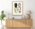 1879 Montrichardia linifera antique botanical print, Plate 22 by Heinrich Wilhelm Schott, framed above a natural oak sideboard in a bright, neutral living room.