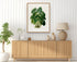 1879 Xanthosoma maximiliani antique botanical print, Plate 31 by Heinrich Wilhelm Schott, framed above a natural oak sideboard in a bright, neutral living room.