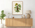 1879 Philodendron imperiale antique botanical print, Plate 40 by Heinrich Wilhelm Schott, framed above a natural oak sideboard in a bright, neutral living room.